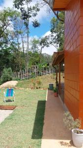 a bench sitting on the grass next to a house at Chalé da Montanha in São Roque