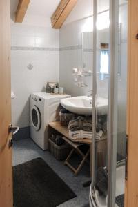Un baño con lavadora y lavabo. en Luggishof, en Campo Tures