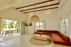 a living room with a red couch and a table at Peaceful Villa with Private Pool Garden Views by Sea N' Rent in Haad Chao Phao