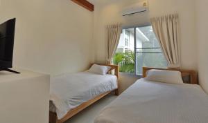 a bedroom with two beds and a television and a window at Peaceful Villa with Private Pool Garden Views by Sea N' Rent in Haad Chao Phao +22 photos