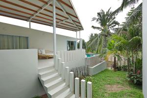 a white house with stairs and a swimming pool at Peaceful Villa with Private Pool Garden Views by Sea N' Rent in Haad Chao Phao