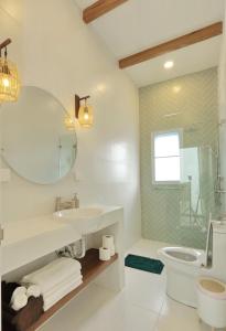 a bathroom with a sink and a toilet and a mirror at Peaceful Villa with Private Pool Garden Views by Sea N' Rent in Haad Chao Phao