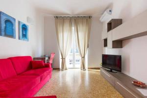 a living room with a red couch and a tv at Casa Vacanze Luli in La Spezia