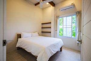 a bedroom with a white bed and a window at Serene Jungle Escape with Private Pool by Sea N' Rent in Haad Chao Phao +45 photos
