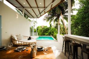 a patio with a table and chairs and a swimming pool at Serene Jungle Escape with Private Pool by Sea N' Rent in Haad Chao Phao