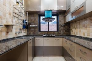 a large kitchen with a sink and a window at Royale Enclave by JadeCapsNr.Manipal Hosp. in Ballygunge +13 photos