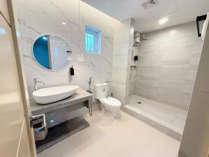 a bathroom with a sink and a toilet and a tub at Casa Sakura Family Room in Calamba