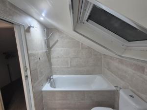 a bathroom with a bath tub and a toilet at The Prestwick Pad in Prestwick +16 photos