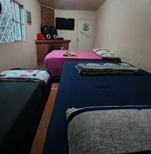 サン・ガブリエウにあるCasa familiarのピンクとブルーのシーツが備わる客室のベッド2台 +4枚の写真