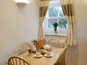 a dining room table with a tea set on it at Meadow Cottage in St Just