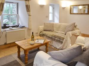 a living room with a couch and a table at Meadow Cottage in St Just