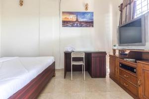 a bedroom with a bed and a desk with a television at Villa Vedic Oasis by JadeCapsPool4 BHKAC in Sikarpur