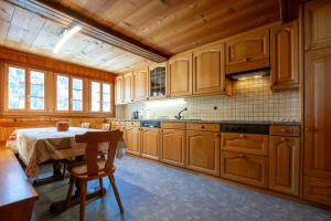 a kitchen with wooden cabinets and a table in it at Ferienwohnung Schleif in Niederwald