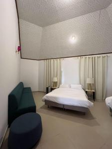 a bedroom with a bed and a green chair at Peace Farm in Hatta +33 photos