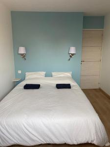 een slaapkamer met een groot wit bed met twee blauwe muren bij Charming house - Grand Village Plage in Grand-Village-Plage