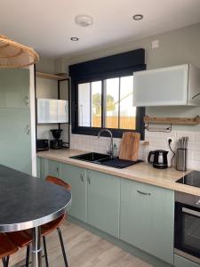 een keuken met een spoelbak en een aanrechtblad bij Charming house - Grand Village Plage in Grand-Village-Plage