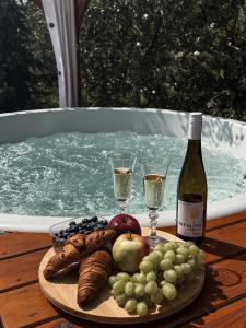 a plate of food with wine and grapes on a table at Magiczny Zakątek Bałtów in Bałtów
