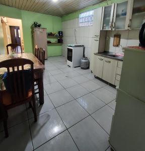 サン・ガブリエウにあるCasa familiarのテーブルと椅子と冷蔵庫のあるキッチン