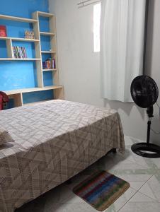 a bedroom with a bed and a book shelf at Casa a 5 minutos da Sede da COP30 in Belém