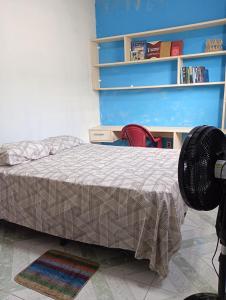 a bedroom with a bed and a book shelf at Casa a 5 minutos da Sede da COP30 in Belém +4 photos