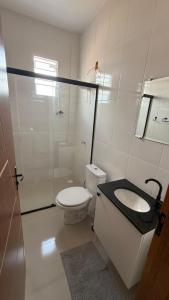 a white bathroom with a toilet and a sink at Cabanos Prime Hotel e Residencial in Barcarena +11 photos