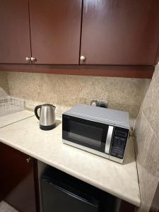 eine Mikrowelle auf einer Theke in einer Küche in der Unterkunft Maju Suites Berjaya Times Square in Gua Sai