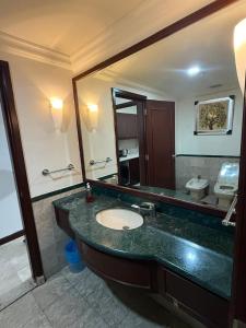 ein Badezimmer mit Waschbecken und Spiegel in der Unterkunft Maju Suites Berjaya Times Square in Gua Sai