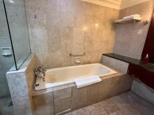 ein Badezimmer mit Badewanne mit Dusche und Waschbecken in der Unterkunft Maju Suites Berjaya Times Square in Gua Sai + 15 Fotos