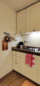 a kitchen with white cabinets and a stove top oven at Sant'Orso Cozy Home in Cogne +43 photos