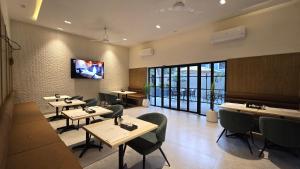 a restaurant with tables and chairs and a tv on the wall at Central Residence by Paramount Hospitality in Karachi