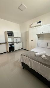 a white bedroom with a large bed and white cabinets at Cabanos Prime Hotel e Residencial in Barcarena
