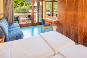 een kamer met een bed, een tafel en stoelen bij Hotel Royal in Garda