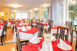 een restaurant met rode en witte tafels en stoelen bij Hotel Royal in Garda