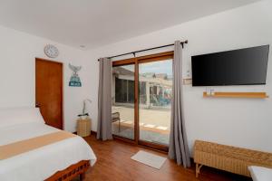 ein Schlafzimmer mit einem Bett und einem Fernseher an der Wand in der Unterkunft Balay Angkan Beachfront Villas Zambales in Cabangan