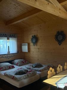 a room with two beds in a log cabin at Domek drewniany in Piekielnik