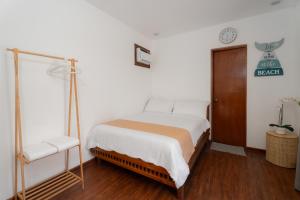 ein Schlafzimmer mit einem Bett und einer Uhr an der Wand in der Unterkunft Balay Angkan Beachfront Villas Zambales in Cabangan