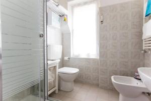 a white bathroom with a toilet and a sink at Casa Vacanze Luli in La Spezia +9 photos