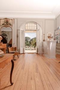 a living room with a wooden floor and a large window at Château du Clair de Lune - Boutique Luxury Hotel in Biarritz