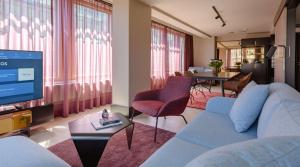 a living room with a blue couch and a tv at Marski by Scandic in Helsinki