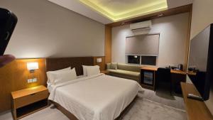 a hotel room with a bed and a couch at Central Residence by Paramount Hospitality in Karachi