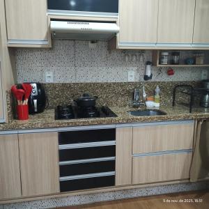 a kitchen with a stove and a sink at Apartamento Embaúbas in São José +6 photos