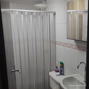 a white shower curtain in a bathroom with a sink at Apartamento Embaúbas in São José