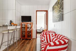 a living room with a red and white striped couch at LUGA: Peaceful Retreat | Lagoon & Imbituba in Imbituba