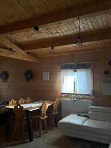a living room with a table and chairs and a couch at Domek drewniany in Piekielnik