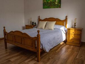 ein Schlafzimmer mit einem Holzbett und zwei Nachttischen in der Unterkunft Live Adeje Taucho Relax Place with Terrace in Adeje