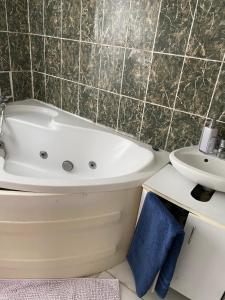 a bathroom with a bath tub and a sink at Privat szobak 3 in Budaörs