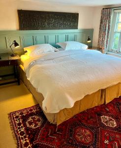 a bedroom with a large bed and a rug at Lamb Inn in Wartling