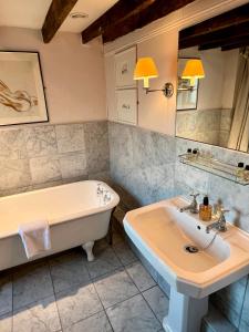 a bathroom with a tub and a sink at Lamb Inn in Wartling