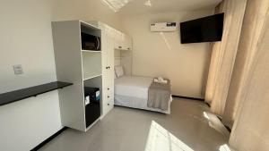 a small room with a bed and a television at Cabanos Prime Hotel e Residencial in Barcarena