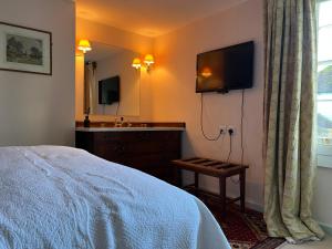 a bedroom with a bed and a television on the wall at Lamb Inn in Wartling +19 photos